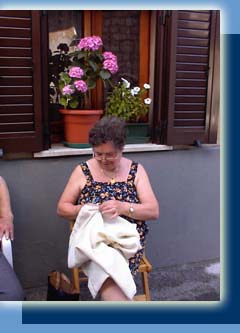 Egiziana Bettini passes the time by 
knitting a tablecloth outside her home