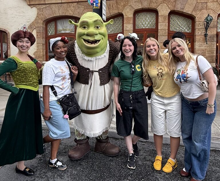 Students pose with actors dressed as Shrek and other characters at Universal Studios Japan