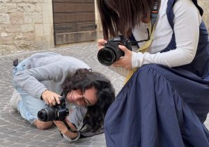 Two students, Kris Miron and Yuying Guo, take photographs during Corpus Domini in Cagli, Italy, June 2, 2024.